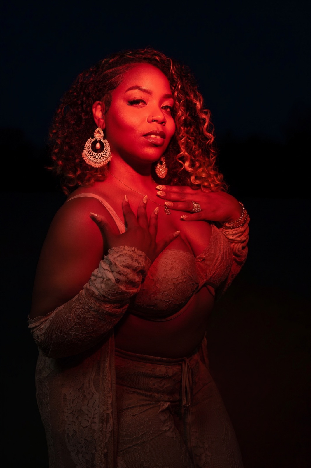 Red-lit portrait with lace gloves and a dark backdrop