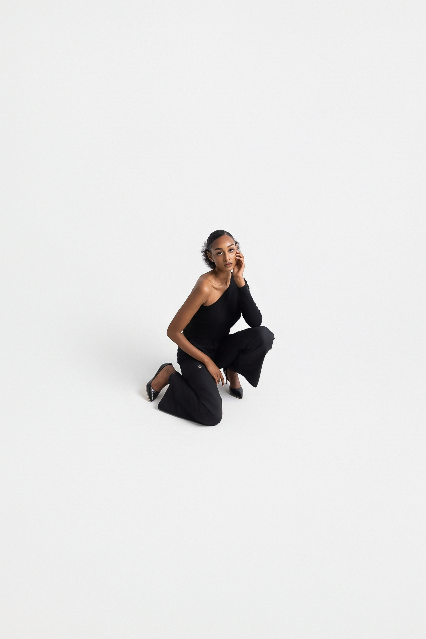 Studio fashion portrait in black against a white backdrop